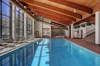 a large swimming pool with chairs in a building at 2084 The Pines condo in Keystone