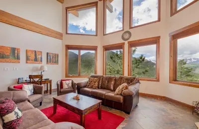 a living room with couches and windows at Elk Summit Vacation Home at Windcliff home in Estes Park