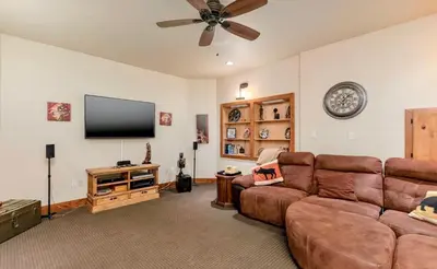 a living room with a couch and a flat screen tv at Elk Summit Vacation Home at Windcliff home in Estes Park