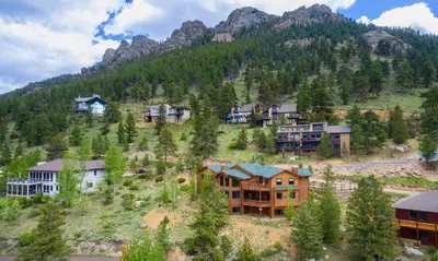 a group of houses on a hill in front of a mountain at Elk Summit Vacation Home at Windcliff home in Estes Park