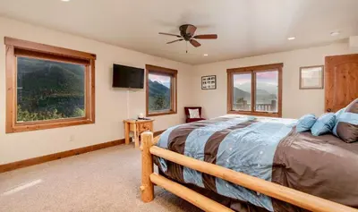 a bedroom with a bed and a ceiling fan at Elk Summit Vacation Home at Windcliff home in Estes Park