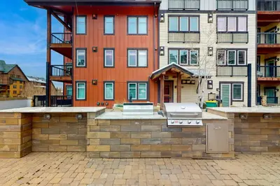 a house with a grill in front of a building at Ski-In Ski-Out Modern Mountain Condo in Winter Park