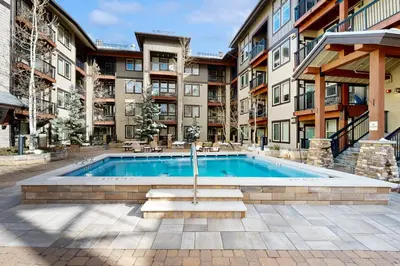 a swimming pool in front of a building at Ski-In Ski-Out Modern Mountain Condo in Winter Park