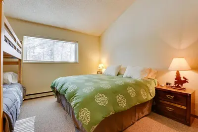 a bedroom with a bed and a bunk bed at Colorado Ski Condo in the Heart of Winter Park in Winter Park