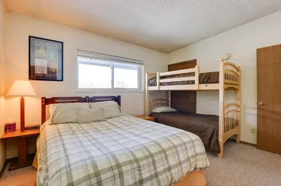 a bedroom with a bed and bunk beds at Colorado Ski Condo in the Heart of Winter Park in Winter Park