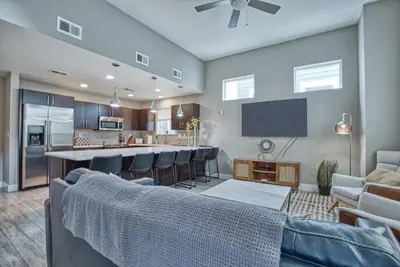 a living room with a couch and a kitchen at Modern Townhome near Old Town, Breweries, & River! in Fort Collins