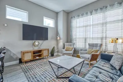 a living room with a couch and a tv at Modern Townhome near Old Town, Breweries, & River! in Fort Collins