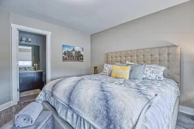 a bedroom with a large bed with a blue comforter at Modern Townhome near Old Town, Breweries, & River! in Fort Collins