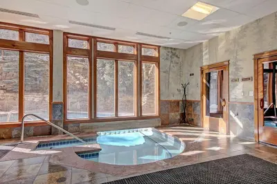 a hot tub in a room with windows at 3059 The Timbers condo in Keystone