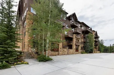 a large brick building with trees in front of it at 3059 The Timbers condo in Keystone
