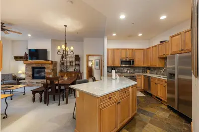 a kitchen with wooden cabinets and a dining room at 3059 The Timbers condo in Keystone