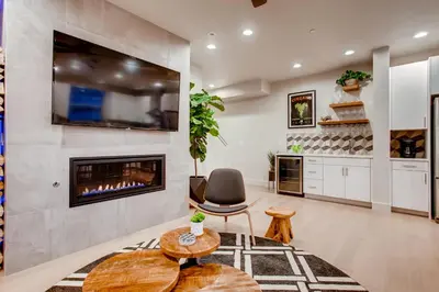 a living room with a fireplace and a chair at Old Town Swank - Brand New To Brewery District! in Fort Collins