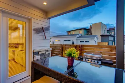 a patio with a glass table on a balcony at Old Town Swank - Brand New To Brewery District! in Fort Collins