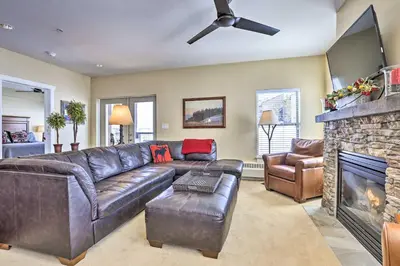 a living room with a leather couch and a fireplace at Ski-InandSki-Out Granby Base Camp Escape with Balcony in Granby