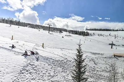 a snow covered slope with people on a ski lift at Ski-InandSki-Out Granby Base Camp Escape with Balcony in Granby