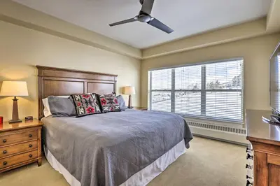 a bedroom with a bed with a ceiling fan and a window at Ski-InandSki-Out Granby Base Camp Escape with Balcony in Granby