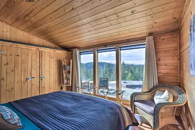 a bedroom with a bed and a large window at 2 Mi to St Marys Glacier Modern Cabin with Hot Tub in Idaho Springs