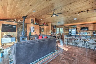 a living room with a couch and a kitchen at 2 Mi to St Marys Glacier Modern Cabin with Hot Tub in Idaho Springs