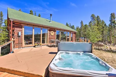 a hot tub on a deck next to a cabin at 2 Mi to St Marys Glacier Modern Cabin with Hot Tub in Idaho Springs