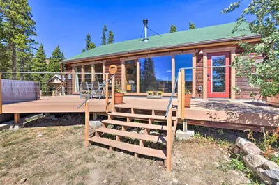 a house with a wooden porch and a wooden staircase at 2 Mi to St Marys Glacier Modern Cabin with Hot Tub in Idaho Springs