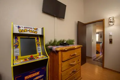 a room with a dog man arcade game next to a dresser at Snowblaze Condos Building C unit 24 in Winter Park