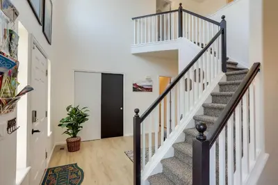 a staircase in a home with white walls and wood floors at Spacious Thornton Home 15 Mi to Downtown Denver! in Thornton