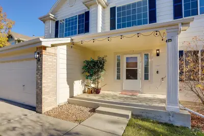 a white house with a door and a garage at Spacious Thornton Home 15 Mi to Downtown Denver! in Thornton