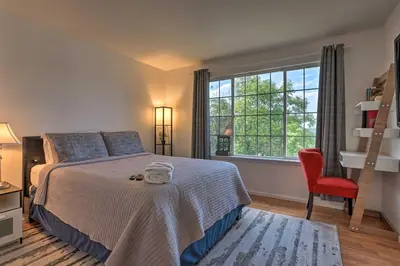 a bedroom with a bed and a red chair and a window at Spacious Thornton Home 15 Mi to Downtown Denver! in Thornton