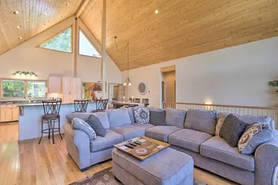 a living room with a couch and a kitchen at Ski and Bike Home with Deck and Hot Tub in Granby! in Granby
