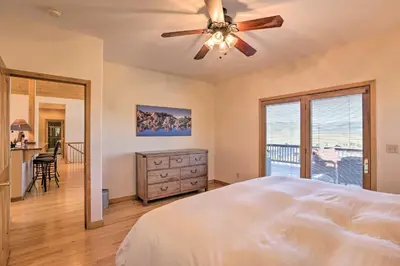 a bedroom with a bed and a ceiling fan at Ski and Bike Home with Deck and Hot Tub in Granby! in Granby