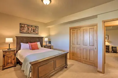a bedroom with a bed with a wooden frame at Ski and Bike Home with Deck and Hot Tub in Granby! in Granby