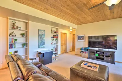 a living room with a leather couch and a tv at Ski and Bike Home with Deck and Hot Tub in Granby! in Granby