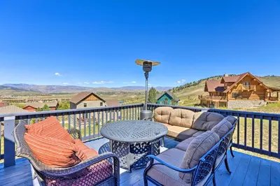 a patio with a table and chairs on a deck at Ski and Bike Home with Deck and Hot Tub in Granby! in Granby