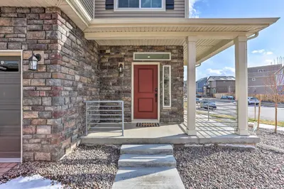 a brick house with a red door and a porch at Modern Aurora Getaway 22 Mi to Downtown Denver in Watkins