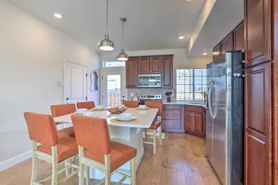 a kitchen with a table with chairs and a refrigerator at Modern Aurora Getaway 22 Mi to Downtown Denver in Watkins