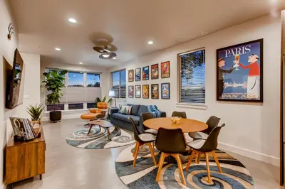 a living room with a table and chairs at Elegant Townhome near Old Town, Breweries and River! in Fort Collins