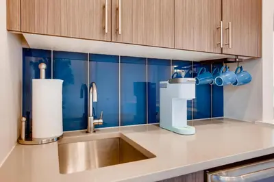 a kitchen with a sink and blue tiles at Elegant Townhome near Old Town, Breweries and River! in Fort Collins
