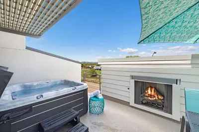 a patio with a hot tub and a fireplace at Elegant Townhome near Old Town, Breweries and River! in Fort Collins