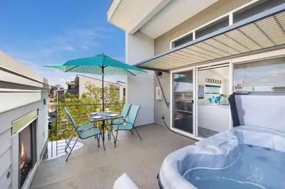 a balcony with a tub and a table and chairs at Elegant Townhome near Old Town, Breweries and River! in Fort Collins