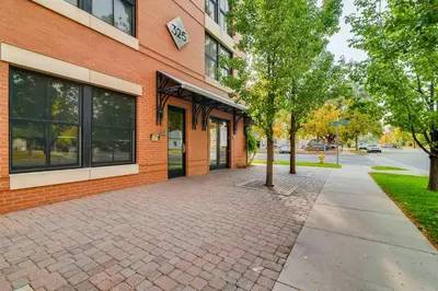 a brick building with a tree in front of it at Old Town Loft Oasis with Amazing Rooftop Deck! in Fort Collins