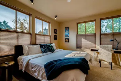 a bedroom with a bed and a desk and windows at Old Town Loft Oasis with Amazing Rooftop Deck! in Fort Collins