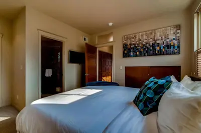 a bedroom with a large white bed with blue pillows at Old Town Loft Oasis with Amazing Rooftop Deck! in Fort Collins