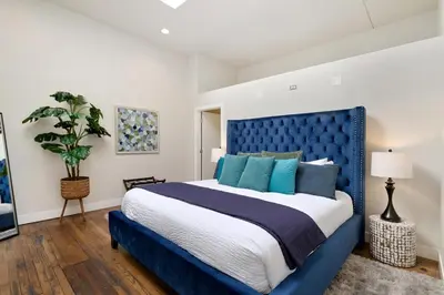 a bedroom with a blue bed with a blue headboard at The Penthouse Loft in the Heart of Old Town! in Fort Collins
