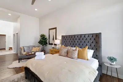 a bedroom with a large bed and a chair at The Penthouse Loft in the Heart of Old Town! in Fort Collins