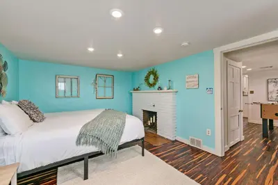 a blue bedroom with a bed and a fireplace at Mulberry Place - A Charming Cottage Near Old Town! in Fort Collins