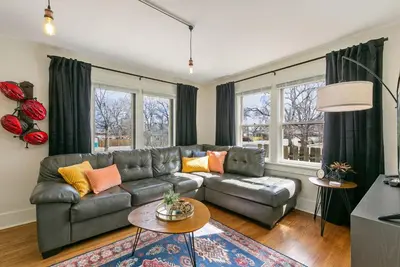 a living room with a couch and a table at Mulberry Place - A Charming Cottage Near Old Town! in Fort Collins