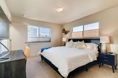 a bedroom with a large bed and two windows at Fancy Townhome near Old Town, Breweries and River! in Fort Collins