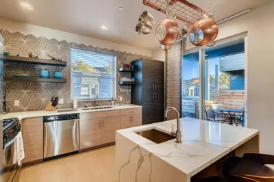a kitchen with a sink and a large window at Fancy Townhome near Old Town, Breweries and River! in Fort Collins