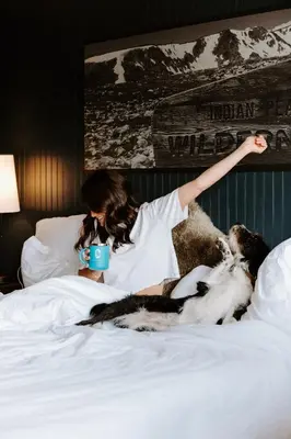 a woman laying on a bed with a dog at Gravity Haus Winter Park in Winter Park