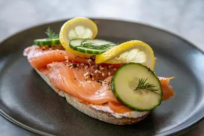 a piece of bread with fish and cucumbers on it at Gravity Haus Winter Park in Winter Park